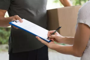 woman signing at the delivery